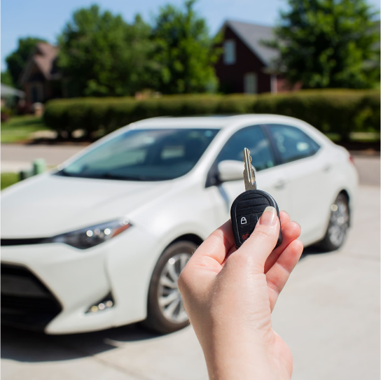 hands holding key in driveway